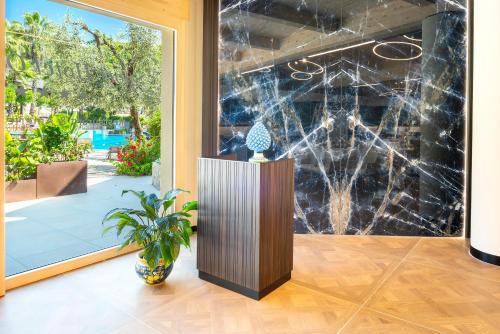 ガルダにあるSporthotel Olimpoのロビーのディスプレイ付きガラス壁