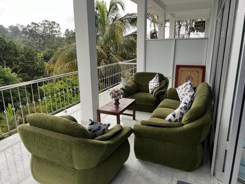 two green chairs and a table on a porch at Ella Berg Haven in Ella