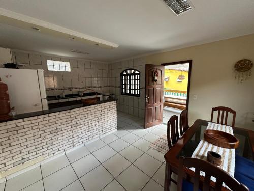 a kitchen and dining room with a table and chairs at Caiçara's house in Praia de Araçatiba