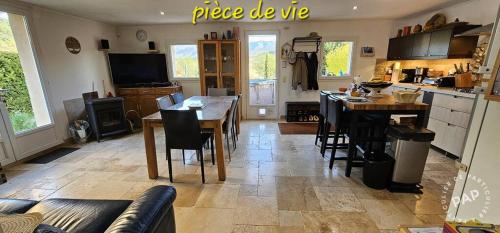 Una cocina y una sala de estar con una mesa y una mesa. en Chez Mich'An Luberon, en Saignon