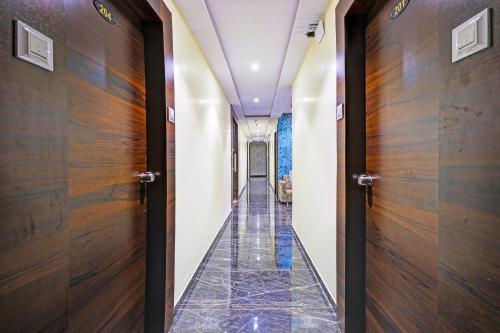 a hallway with wooden doors and tile floors at Hotel O Golden in Vadodara