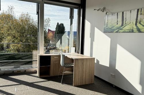 a kitchen with a desk and a large window at Unterkünfte Buchholz in Buchholz in der Nordheide