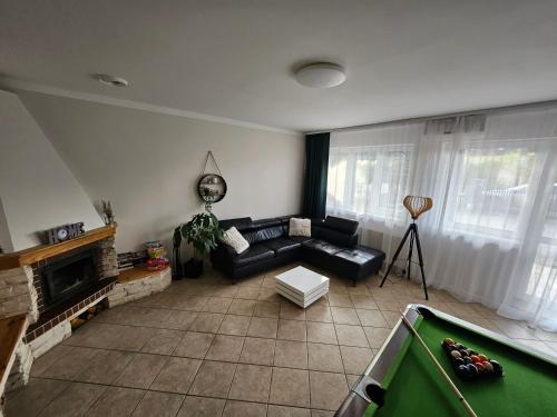 a living room with a couch and a pool table at Dom Pod Świerkiem in Ostróda
