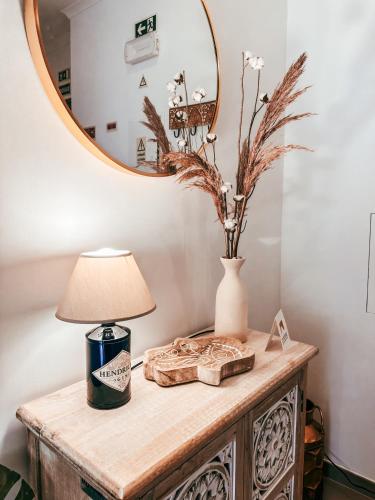 a table with a lamp and a mirror on it at Cosy Apartment Queluz By Gt House in Queluz