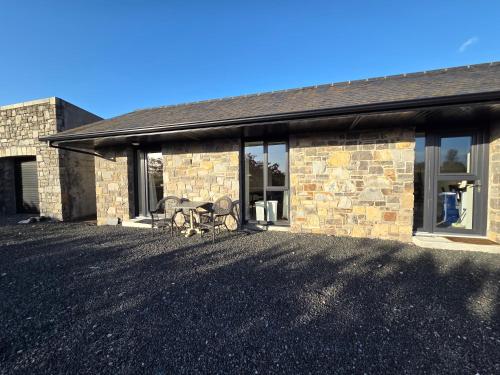 a stone house with a table and chairs in front of it at Kilgar gardens in Kilcock