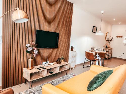 a living room with a couch and a television on a wall at Cosy Apartment Queluz By Gt House in Queluz