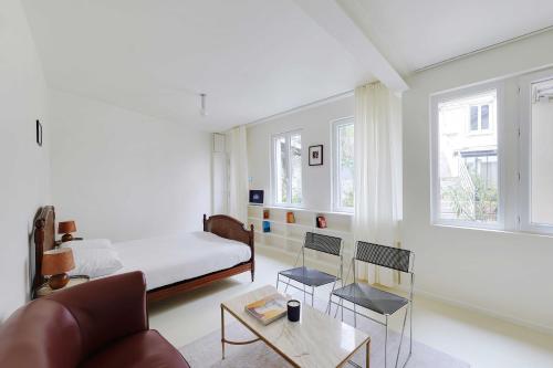a bedroom with a bed and a couch and a table at Cozy Studio 2P – Montmartre in Paris