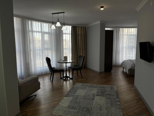 阿斯塔纳71 East Hotel的带桌椅和床的客厅