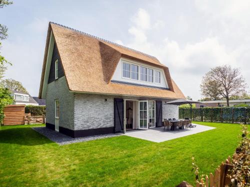 ein Haus mit Satteldach auf einem Rasen in der Unterkunft Pretty Holiday Home in De Koog Texel with Garden in Westermient