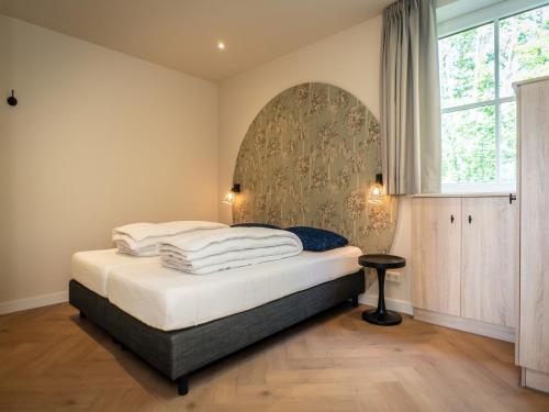ein Schlafzimmer mit einem Bett mit weißen Laken und einem Fenster in der Unterkunft Pretty Holiday Home in De Koog Texel with Garden in Westermient