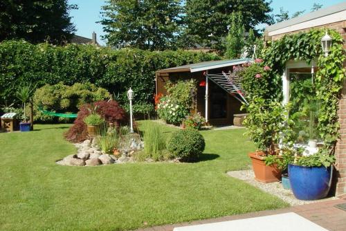 un giardino con piante e fiori in un cortile di Silbermöwe a Fehmarn