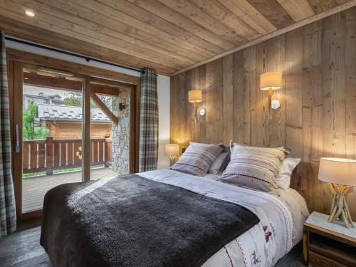 a bedroom with a large bed and a balcony at Duplex Charmant Près des Pistes avec Hammam et Cheminée à Courchevel Le Praz - FR-1-568-8 in Courchevel