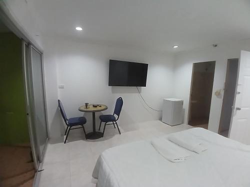 a hotel room with a bed and a table and chairs at Didim Guest House Patong in Patong Beach