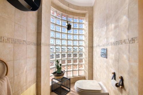 a bathroom with a toilet and a window at Vila Picota in Cerro da Zorra