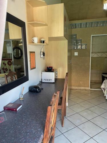 Una cocina con una mesa con bancos y un microondas. en Texas Guesthouse, en Phalaborwa