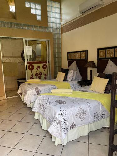 un par de camas en una habitación en Texas Guesthouse, en Phalaborwa