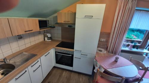 eine kleine Küche mit einem weißen Kühlschrank und einer Spüle in der Unterkunft Studio für 2 Personen ca 58 qm in Bayerisch Eisenstein, Bayern Bayerischer Wald in Bayerisch Eisenstein