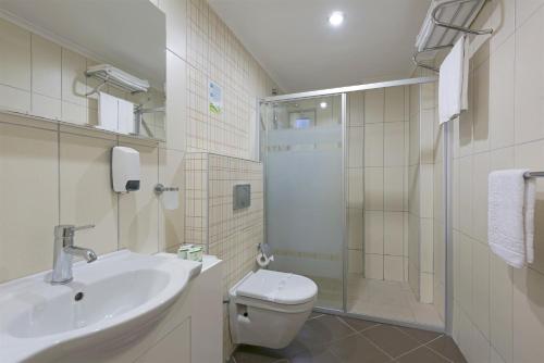 a bathroom with a toilet and a sink and a shower at Club Sidelya Hotel in Side