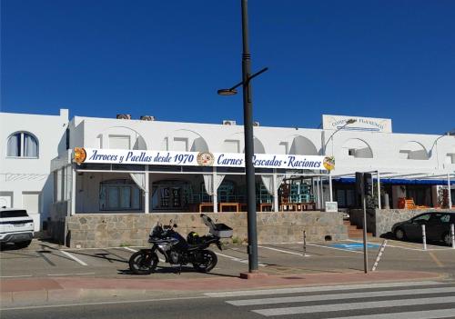 una motocicleta estacionada en un estacionamiento frente a un edificio en El Flamenco, en Mojácar