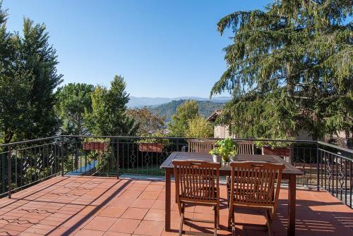 einen Tisch und Stühle auf einer Terrasse mit Aussicht in der Unterkunft Rustikales Natursteinhaus in der Toskana mit großem gemeinschaftlich genutzten Pool - b60232 in Pratovecchio