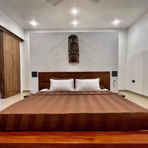 a bedroom with a large bed with a wooden headboard at Shiva Sunrise Resort in Hikkaduwa
