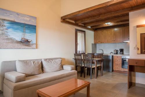 a living room with a couch and a kitchen at To Mpalkoni in Chorefto