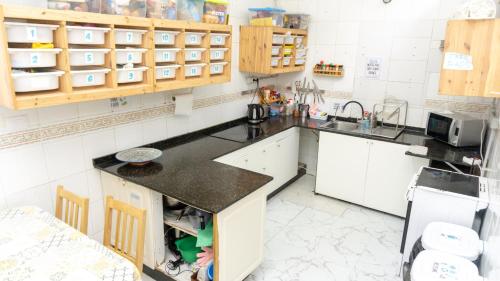 a kitchen with white cabinets and a black counter top at Agüita House in Las Palmas de Gran Canaria