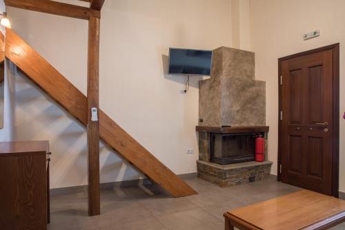 a living room with a fireplace and a tv at To Mpalkoni in Chorefto