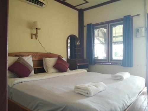 um quarto com uma cama com toalhas em Somphamit Guesthouse em Ban Khon