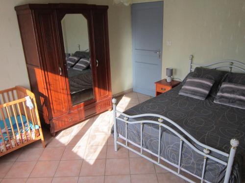 a bedroom with a bed and a dresser and a mirror at Le clos des érables in Montesquieu