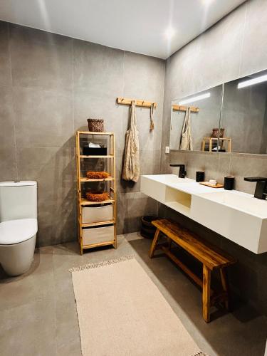 a bathroom with a sink and a toilet and a mirror at Sand and Style, Baie Orientale in Saint Martin