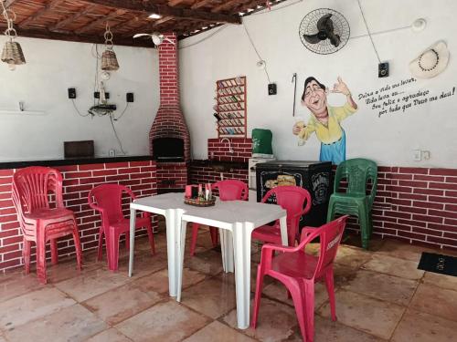 a table and chairs in a room with a painting on the wall at HospedagemCanoa in Aracati