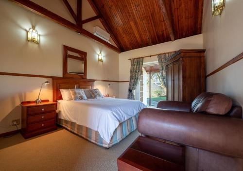 a bedroom with a bed and a couch at Trumpetters Drift Private Wildlife Lodge in Grahamstown