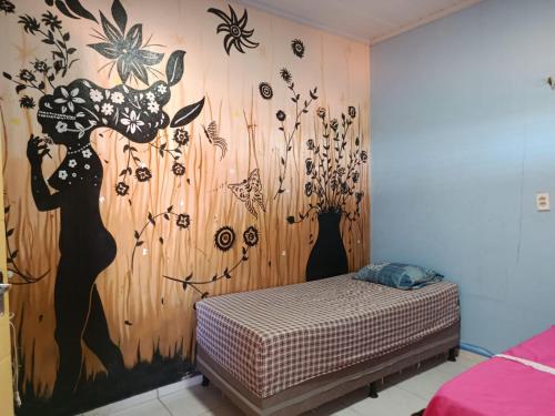 a bedroom with a wall with a mural of flowers at HospedagemCanoa in Aracati