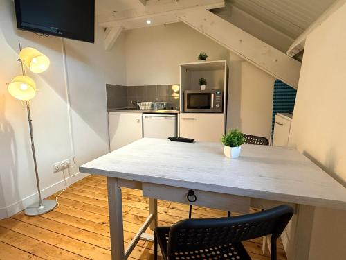 a kitchen with a table and chairs in a room at Studio Rénové - Cœur de Ville WIFI in Dreux