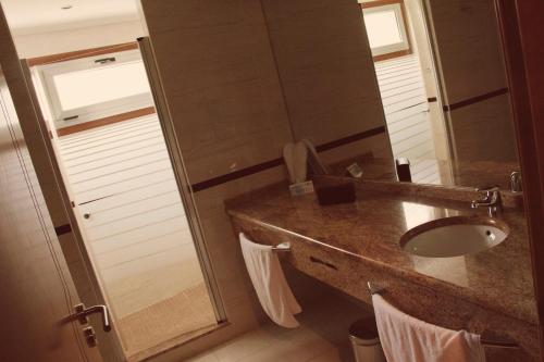 Motel Paraiso في Outeiro de Rei: حمام مع حوض ومرآة