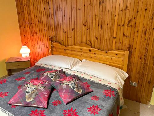 a bedroom with a bed with a wooden headboard at Casa Vacanze - Villa Stefania in Pescocostanzo