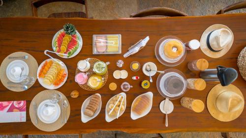 カモシンにあるVilla Caraúbasの食べ物の皿が置かれた木製のテーブル