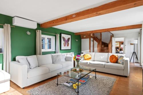 a living room with two white couches and a green wall at Spacious 6-Bed Countryside Home Surrounded by Nature in Sutton Bridge