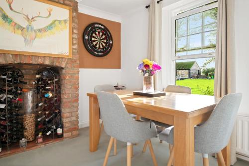 a dining room with a fireplace and a wooden table and chairs at Spacious 6-Bed Countryside Home Surrounded by Nature in Sutton Bridge