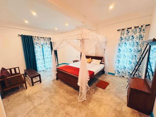 un dormitorio con una cama con dosel en Villa Komalee, en Unawatuna