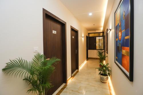 a hallway with potted plants and a brown door at FabHotel Golden Temple Paradise - 50 meters from Golden Temple in Amritsar