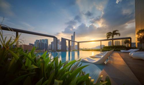 a pool with lounge chairs on a building with a city skyline at Amari Kuala Lumpur in Kuala Lumpur