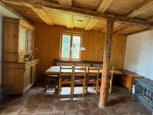 Un comedor con mesa y sillas de madera. en Chalet Hilsen - 2 à 6 personnes, en Linthal