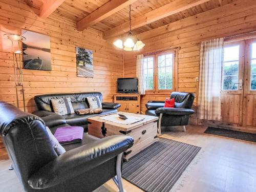 ein Wohnzimmer mit Ledermöbeln in einer Blockhütte in der Unterkunft Holiday Home Zum Stolpseefischer by Interhome in Himmelpfort