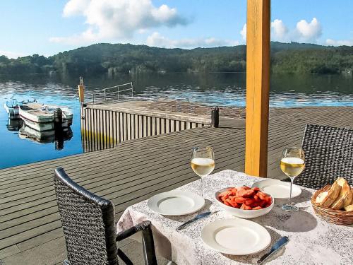 a table with two glasses of wine and a bowl of fruit at Apartment Rorbuen by Interhome in Uggdal