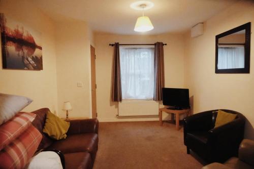 a living room with a couch and a television at The Waverley Hotel in Crewe