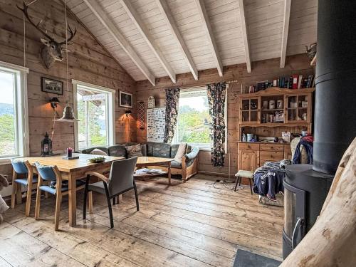 a living room with a table and chairs and a fireplace at Chalet Svanöy by Interhome in Grimeli
