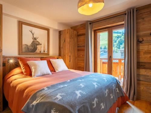 a bedroom with a bed with a deer on it at Bel appartement montagnard 3 chambres pour 6 avec parking au centre de La Clusaz - FR-1-459-245 in La Clusaz