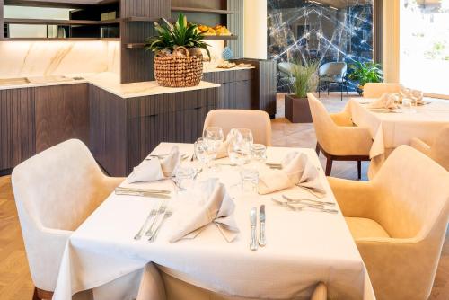 ガルダにあるSporthotel Olimpoの白いテーブルと椅子のあるダイニングルーム